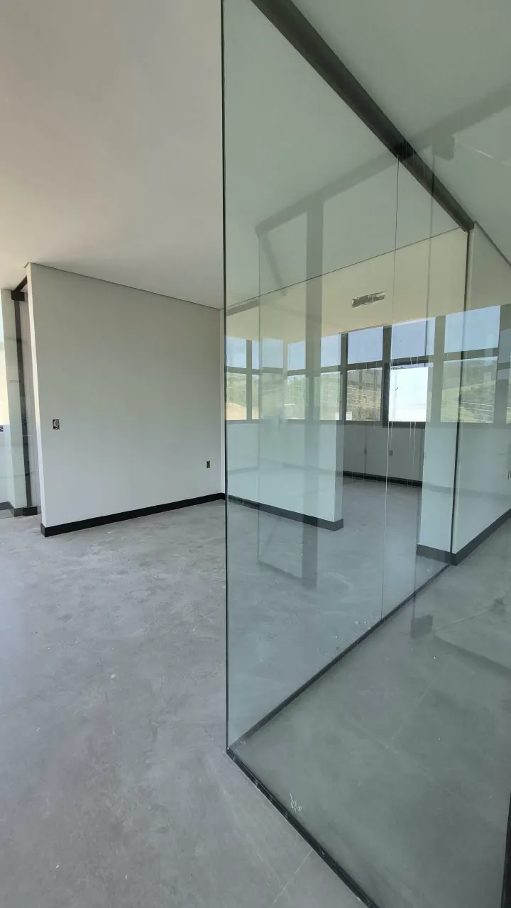 Sala branca finalizada com divisórias de vidro e estruturas pretas na obra da Limpelsul